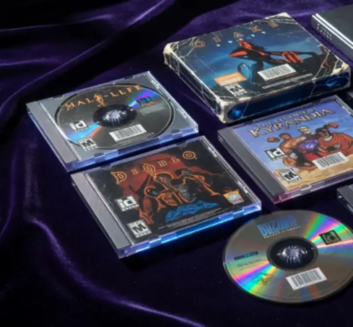 CD-ROM de jeux PC collectors colorés disposés en éventail sur une surface sombre